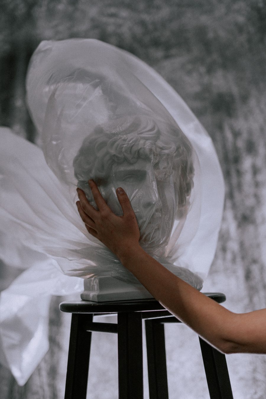 Careful hands protecting a wrapped sculpture